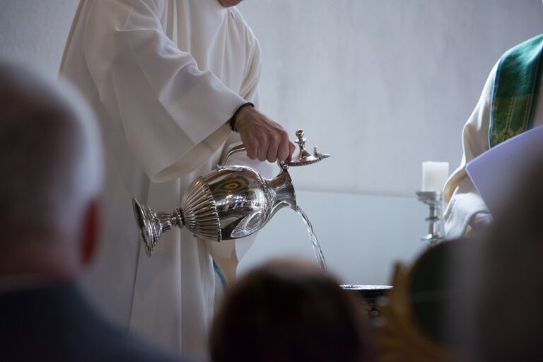 Afbeelding van een priester die water in het doopvont giet